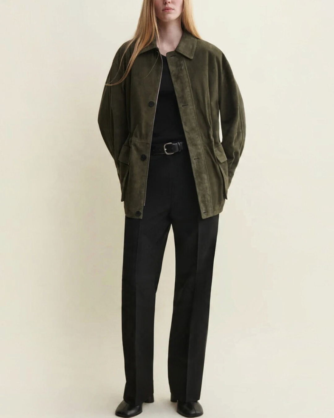 Modèle portant une veste Arma en daim vert foncé avec cordons de serrage, disponible chez Merci Paris