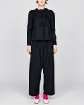 Modèle portant la chemise noire à rayures tennis ELEPH avec fermeture à nœuds et épaules froncées chez Merci Paris