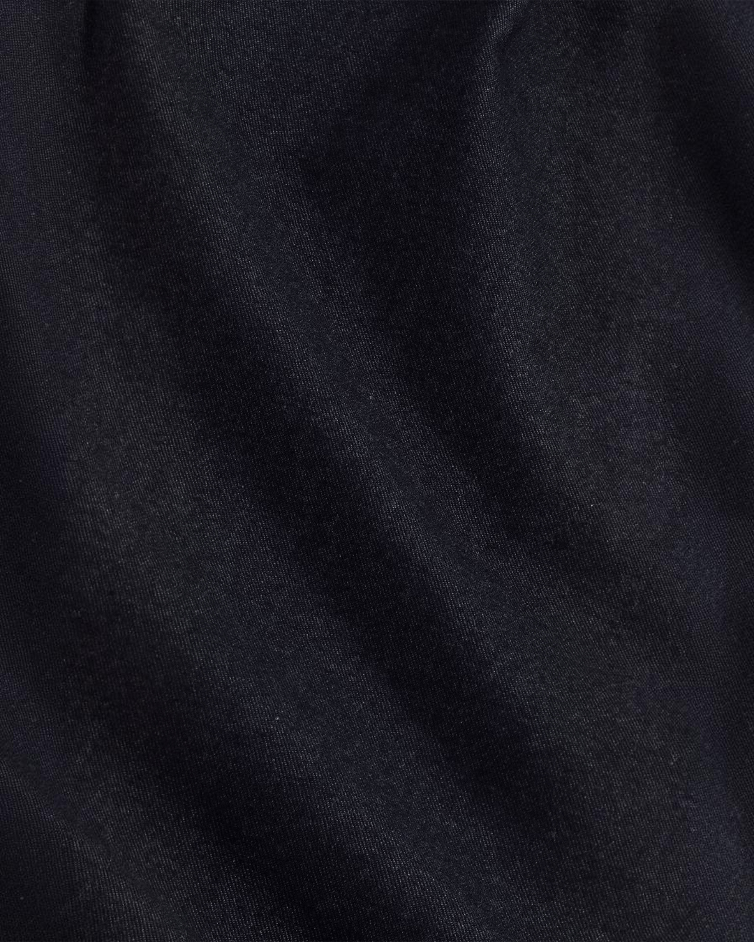 Gros plan sur le tissu sergé chiné bleu marine du pantalon Bill de Merci Paris, texture douce et légèrement brossée
