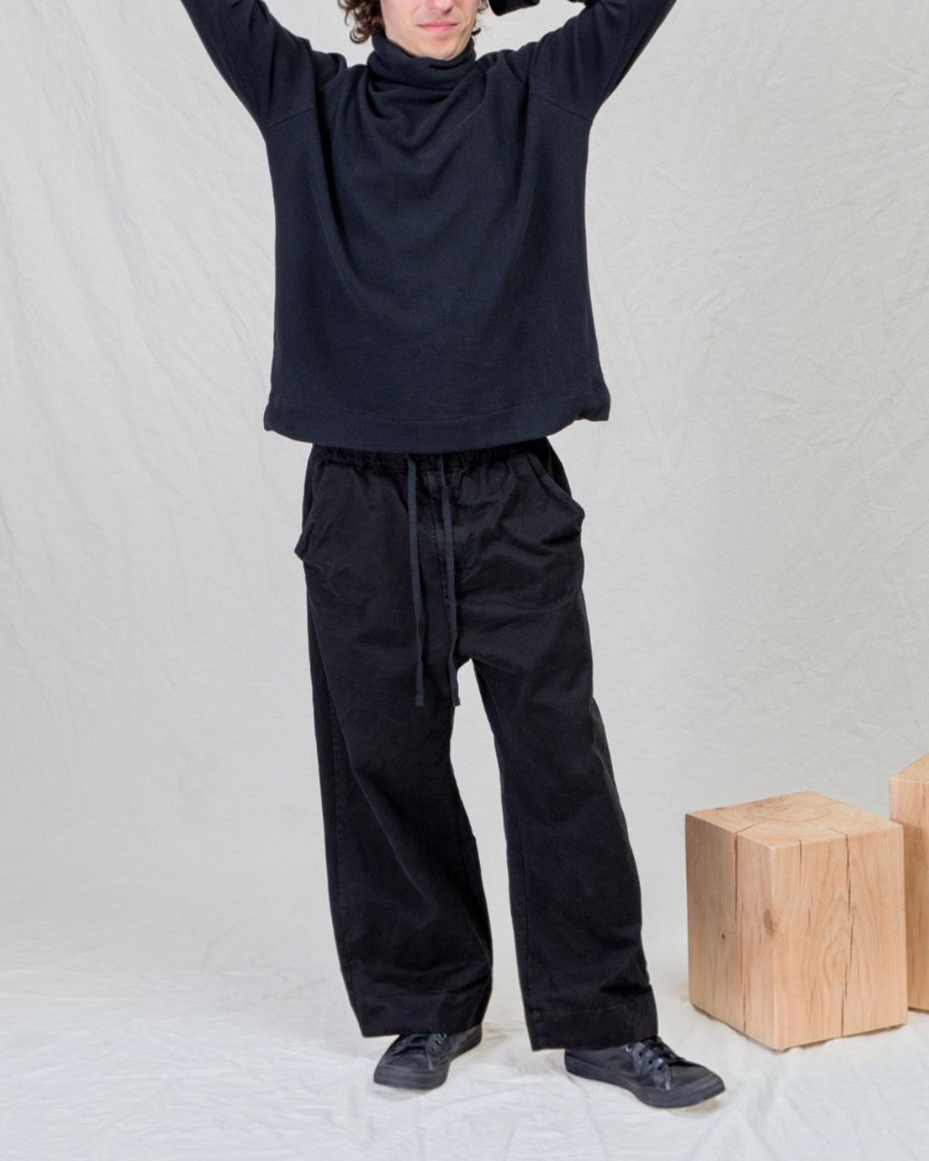 Homme portant un pantalon large noir en coton épais Album Di Famiglia chez Merci Paris, style minimaliste