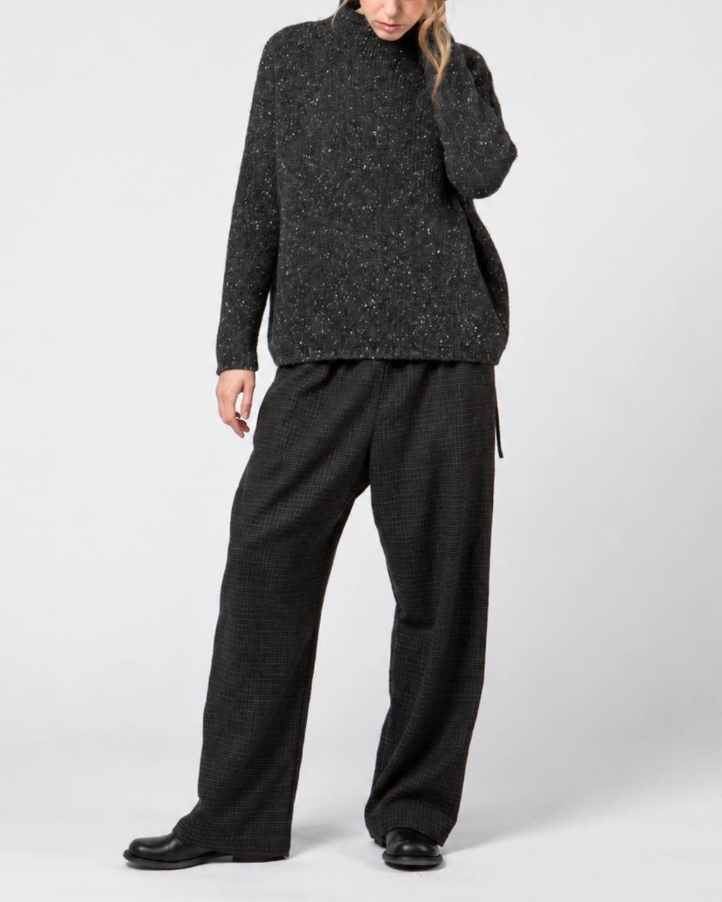 Modèle portant un pantalon large Merci Paris Apuntob bleu marine en laine à carreaux discrets et coupe fluide
