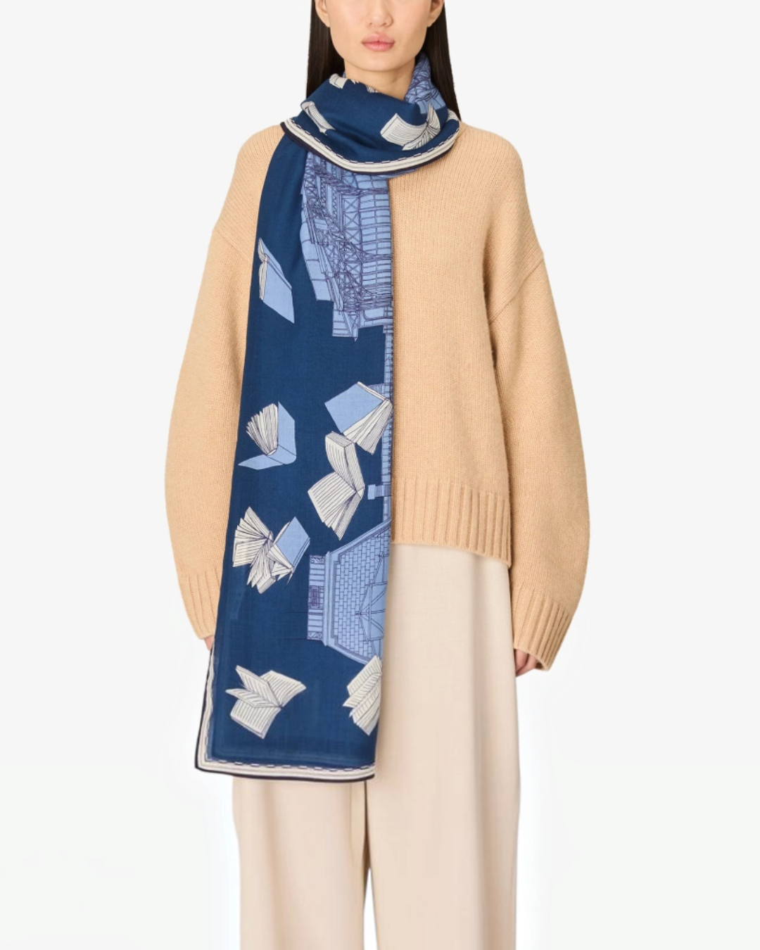 Modèle portant l'écharpe en laine bleue Merci Paris Inoui Editions Vivienne avec un motif imprimé de livres