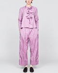 Modèle portant la chemise violette ELEPH à nœuds et pantalon assorti en tissu technique froissé chez Merci Paris