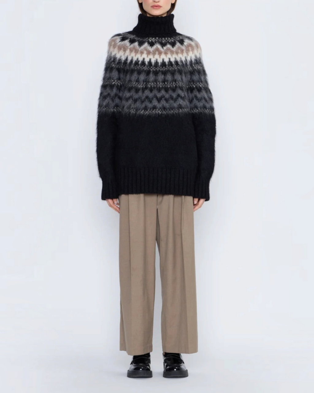 Modèle portant le pull Andean noir en laine d'alpaga brossée Merci Paris avec motif jacquard Fair Isle