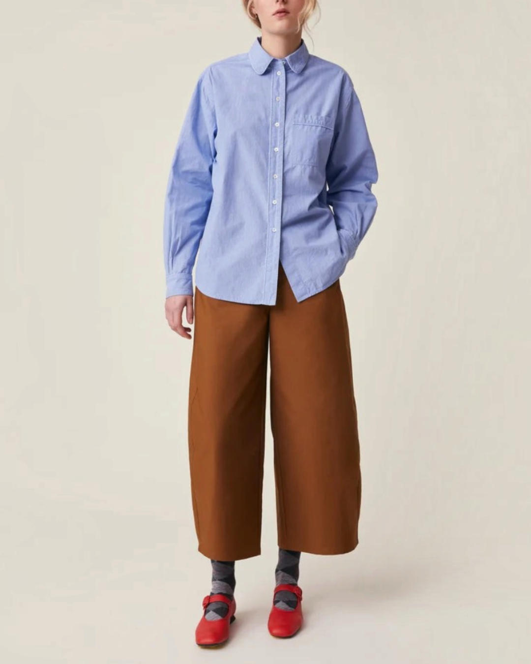 Modèle portant la chemise Henriette en coton bleu de Merci Paris avec col rond, poche poitrine et boutons