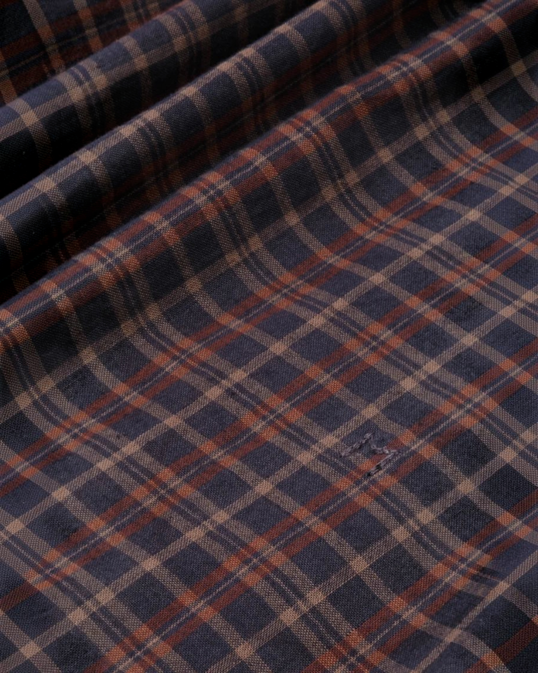 Gros plan sur le tissu en voile de coton à carreaux bleu et marron de la blouse Carmen Moismont chez Merci Paris