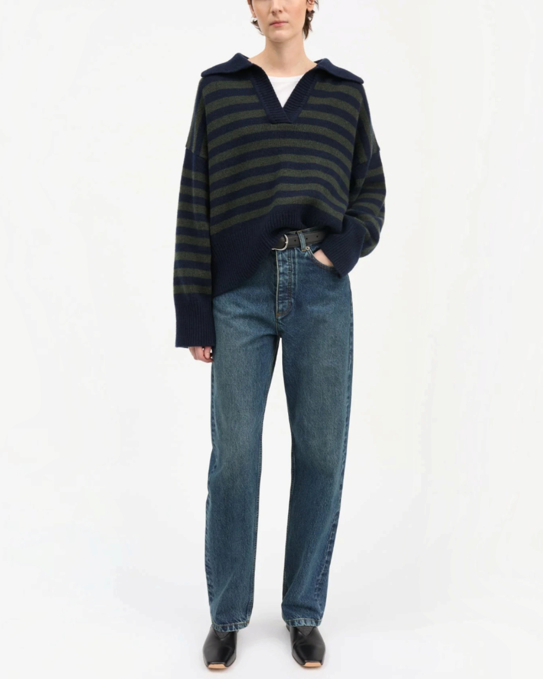 Pull Skall Studio en laine mérinos rayé marine et vert à col V porté par une femme avec un jean bleu