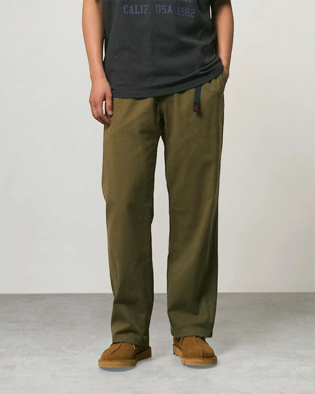 Pantalon droit Gramicci en sergé de coton olive avec ceinture intégrée, porté par un homme, collection Merci Paris