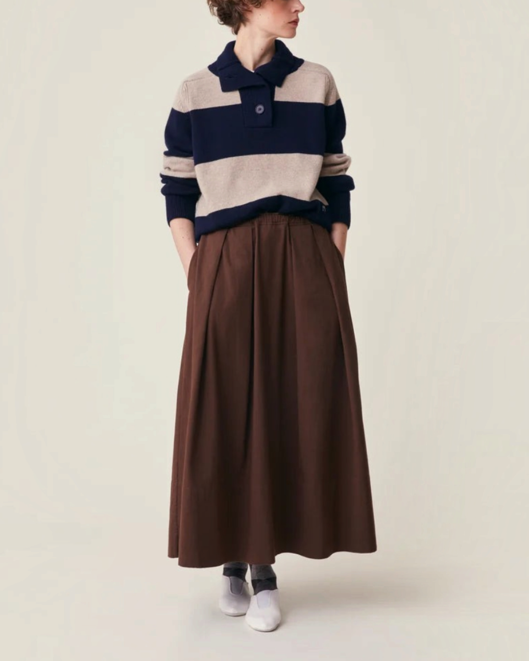 Modèle portant la jupe longue marron Merci Paris Moismont en twill de coton avec plis et taille élastiquée
