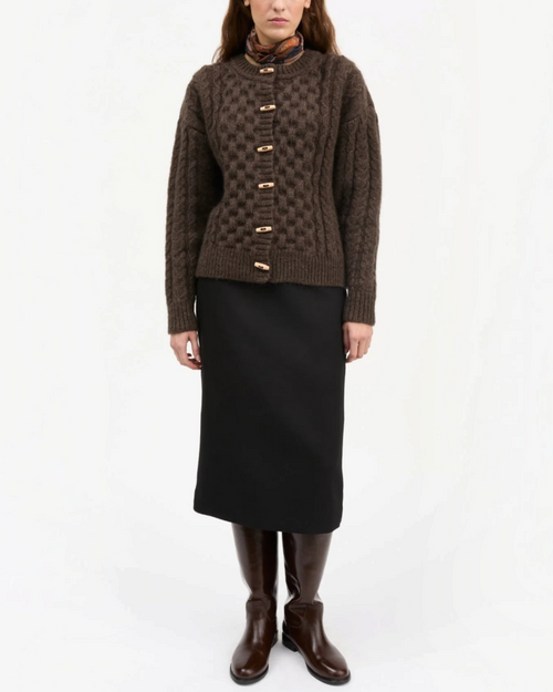Modèle portant le cardigan Lennox marron foncé en laine torsadée de Merci Paris avec des boutons en bois