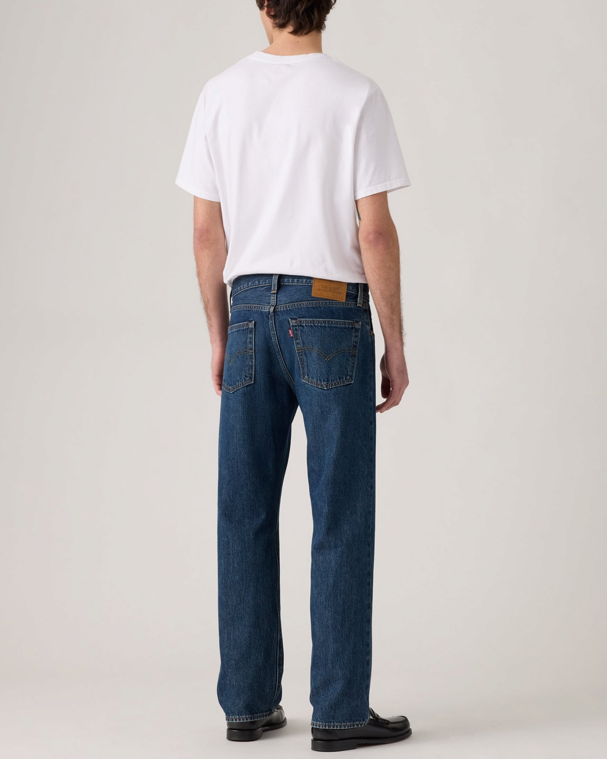 Vue arrière d'un homme portant le jean Levi's 555 Relaxed Straight en denim bleu chez Merci Paris