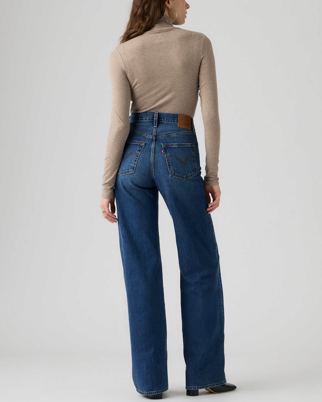 Vue arrière du jean Levi's Ribcage Wide Leg bleu en coton par Merci Paris, porté avec un haut beige à col roulé.