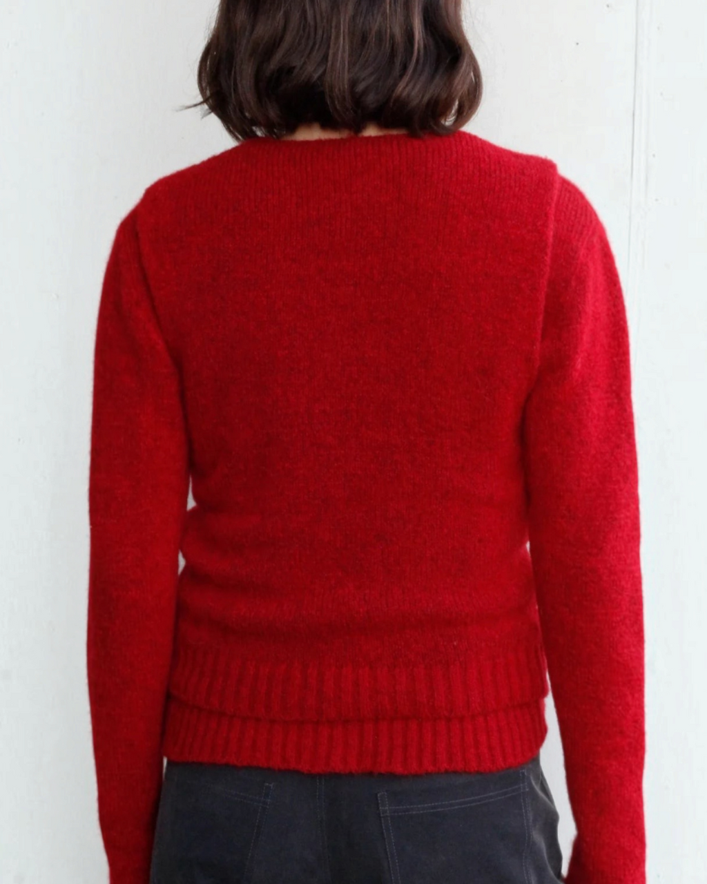 Vue de dos du pull sans manches Lima rouge Merci Paris en maille douce d'alpaga et laine, porté par une femme.