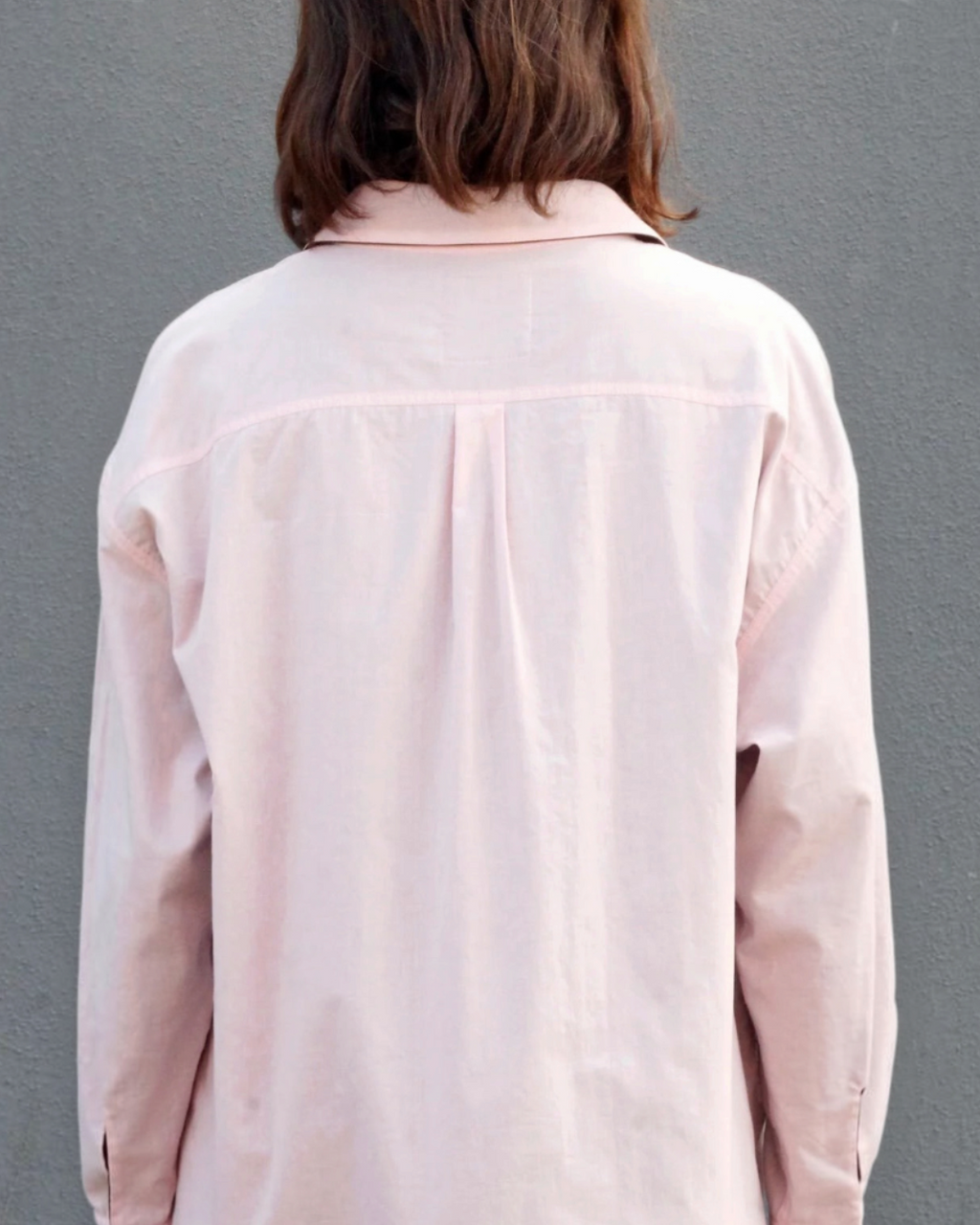 Vue de dos de la chemise réversible Merci Paris en coton biologique rose, coupe oversize et col classique.