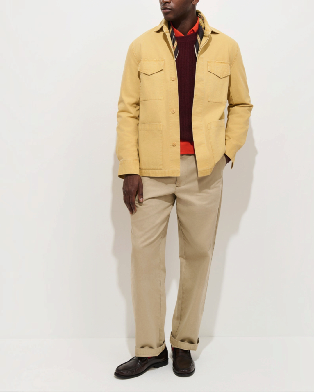 Homme portant la veste New York Merci Paris en toile de coton jaune avec poches utilitaires sur un pull bordeaux