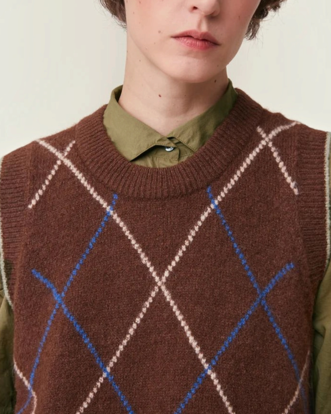 Pull sans manches Merci Paris Moismont Eddy en maille d'alpaga marron à motif losanges colorés porté sur une chemise