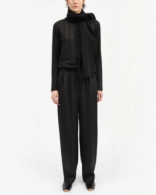 Modèle portant le pantalon Painter noir en laine de Skall Studio chez Merci Paris, coupe large et taille semi-haute.