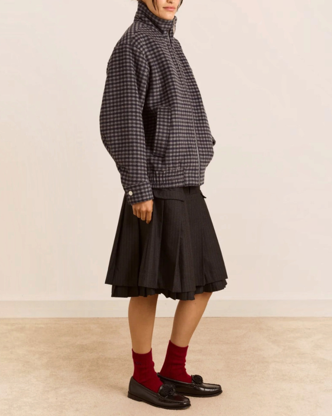 Modèle portant le bomber Pixie Damson Madder en laine recyclée à carreaux vichy bleu et gris avec col montant