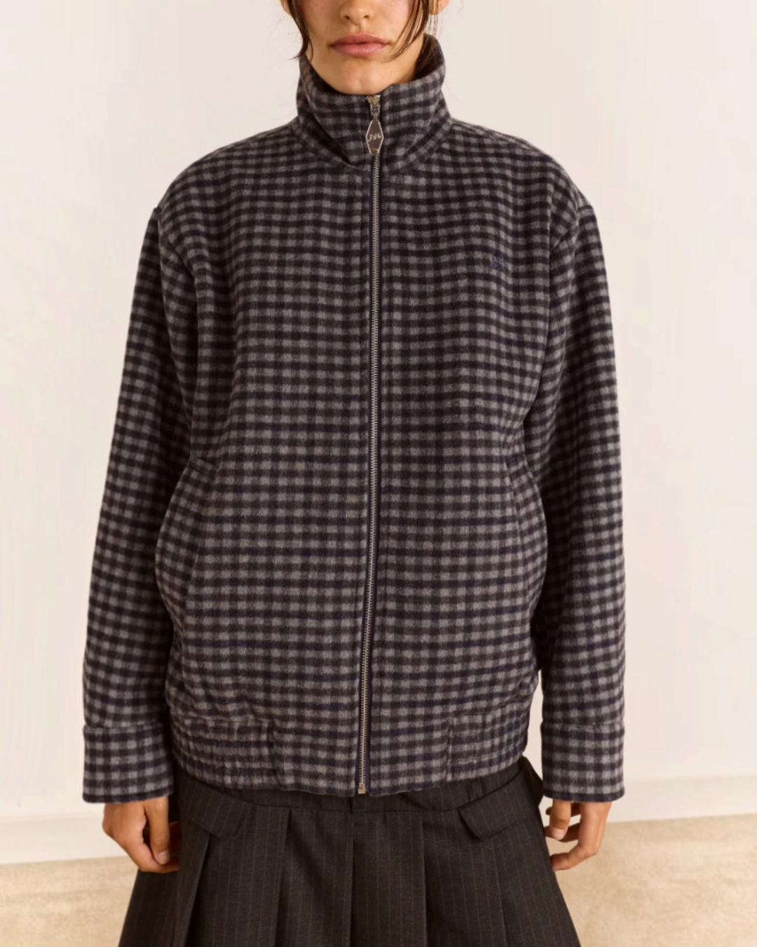 Modèle portant le bomber Pixie Merci Paris en laine recyclée à motif vichy bleu et gris avec col montant zippé