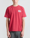 Homme portant un t-shirt Merci Paris Bisous Skateboard rouge délavé en coton avec logo blanc sur la poitrine