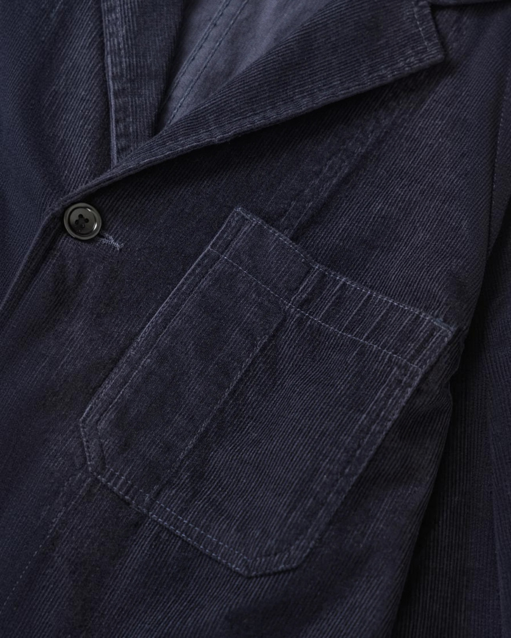 Veste en velours côtelé bleu marine Service Works chez Merci Paris avec poche plaquée et fermeture à trois boutons