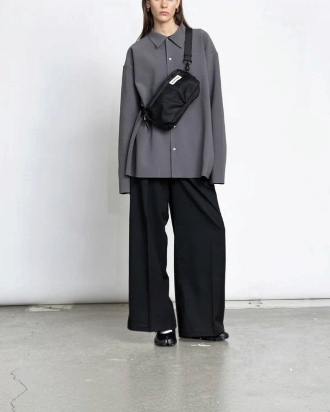 Modèle portant un sac bandoulière noir Merci Paris AY Studios en nylon recyclé au design minimaliste scandinave