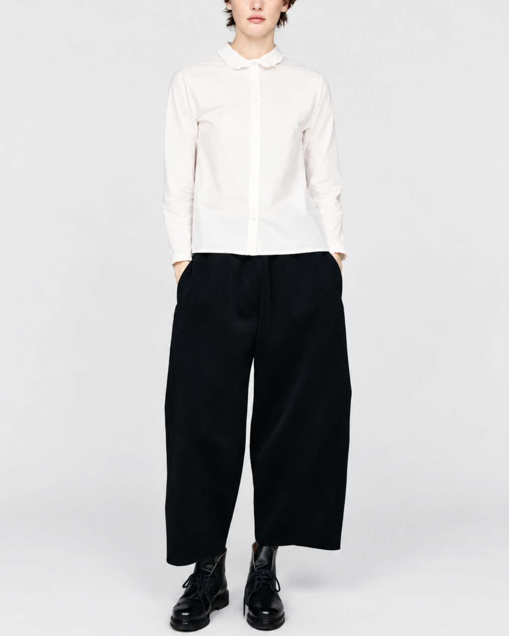 Modèle portant la chemise blanche ELEPH Happy en coton avec col volanté, disponible chez Merci Paris