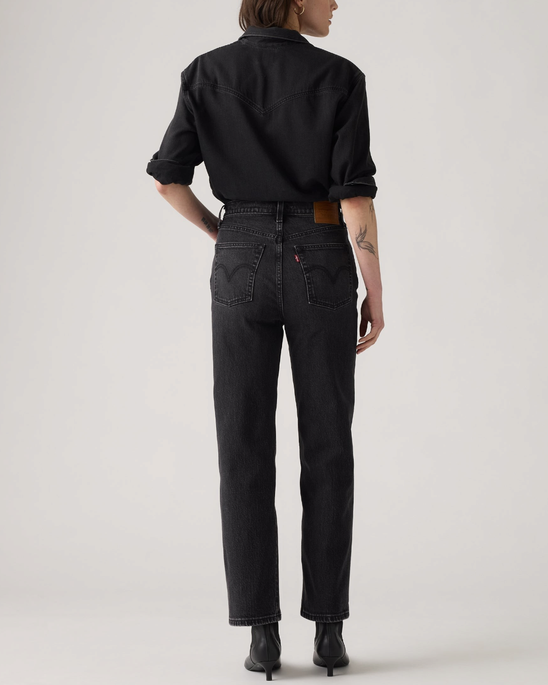 Vue arrière du jean Levi's Ribcage Straight Ankle noir porté par une femme chez Merci Paris avec une chemise noire