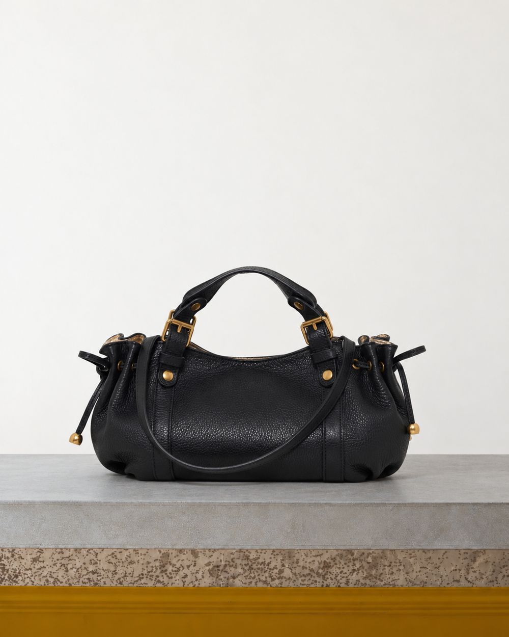 Gerard Darel - Mini Sac À Main En Cuir Grainé Intérieur Métallisé 12H - Noir & Or – Vue sur banc