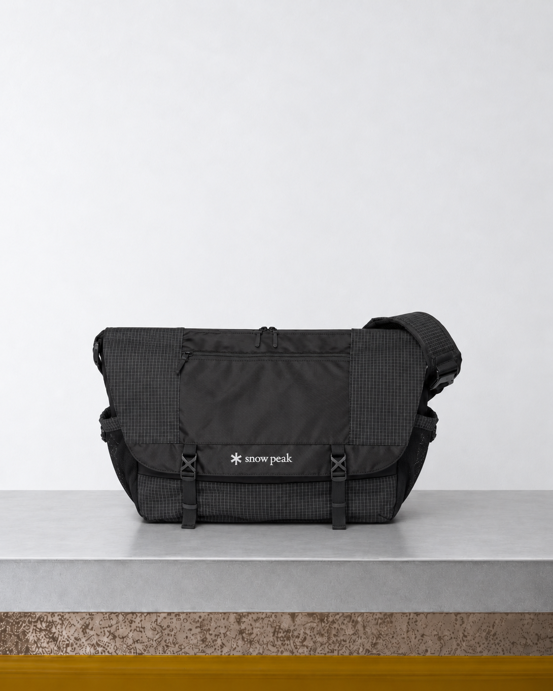 Snow Peak - Sac Messager Carreaux - Noir posé sur le banc