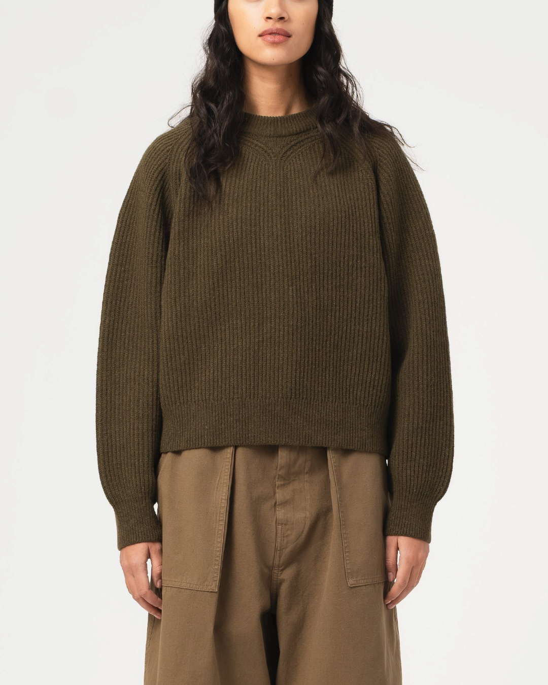 Pull Merci Paris Girls Of Dust Puddle en maille de laine vert kaki coupe courte et col rond porté par une femme